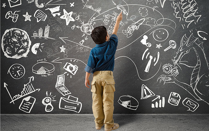 Child writing on Blackboard Shutterstock